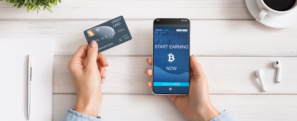 Man hält seine Bitcoin Kreditkarte neben das Handy um zu zahlen