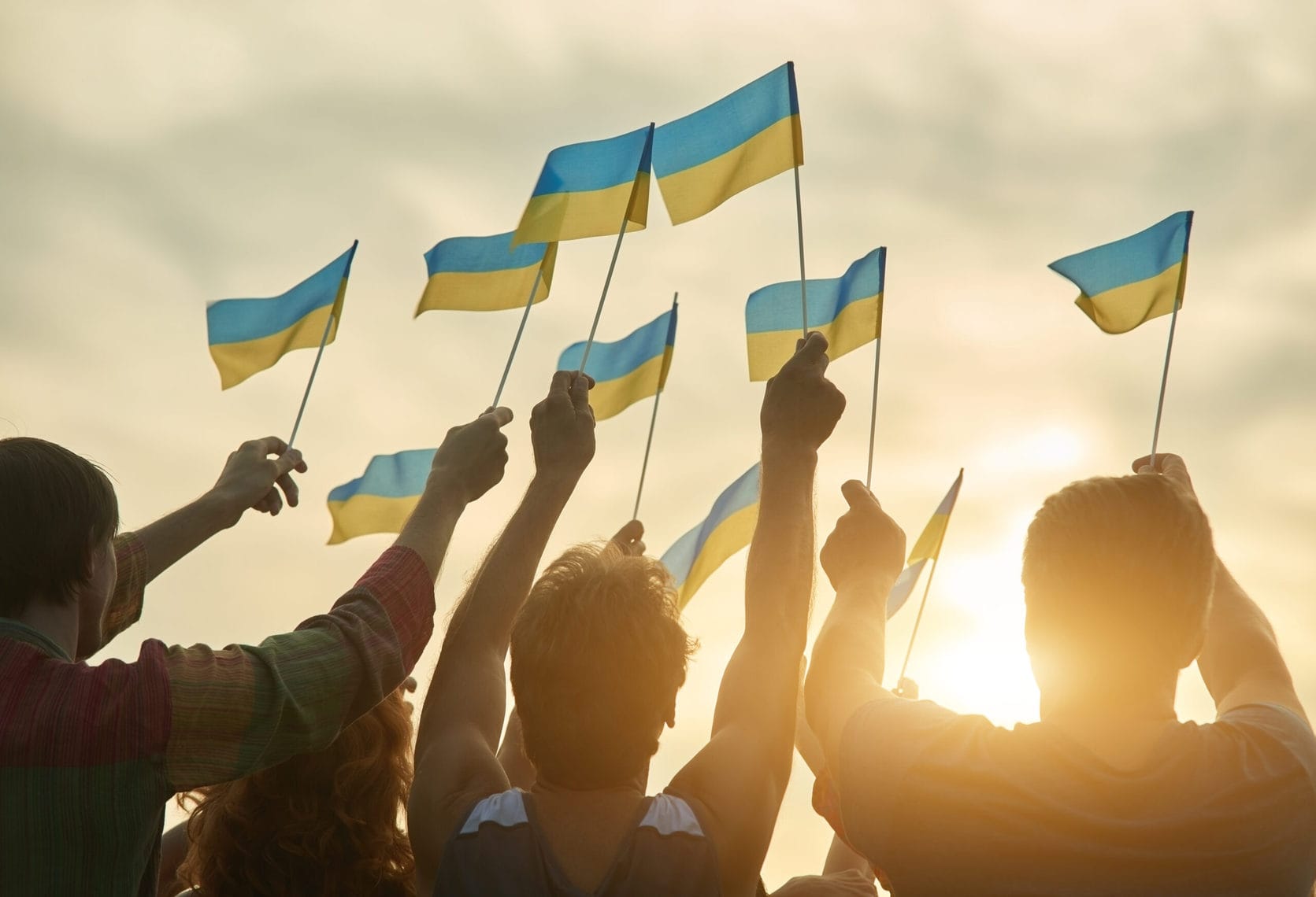 Mehrere ukrainische Flaggen werden von Personen gehalten Blick in Himmel